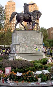 Photo taken in Manhattan's Union Square in the days following September 11th, showing a statue surrounded by memorials, informal shrines, and peace slogans