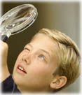 boy looking through a magnifying glass